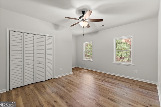 unfurnished bedroom featuring light wood finished floors, a closet, visible vents, and baseboards