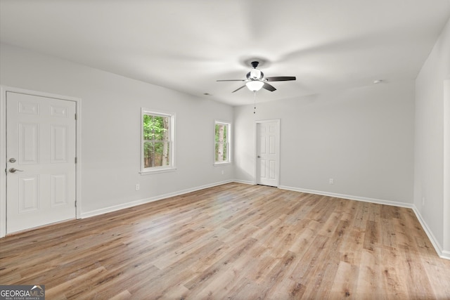 spare room featuring light wood-style floors, baseboards, and ceiling fan