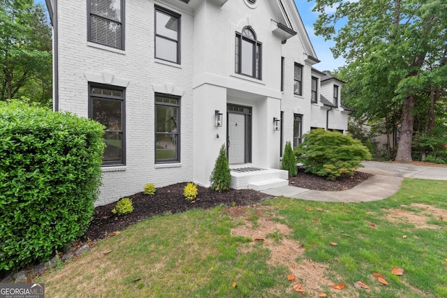 view of front facade with a front yard and brick siding