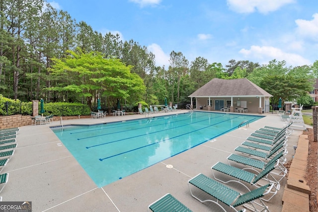 pool with fence and a patio