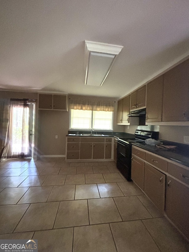 9163 Fair St SW, Covington, GA 30014 - kitchen featuring electric range, dark countertops, a sink, light tile patterned floors, and under cabinet range hood