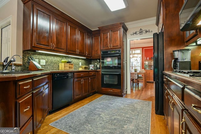 kitchen with ornamental molding, backsplash, black appliances, and light wood-type flooring