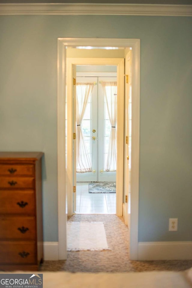 hallway with baseboards, ornamental molding, and french doors