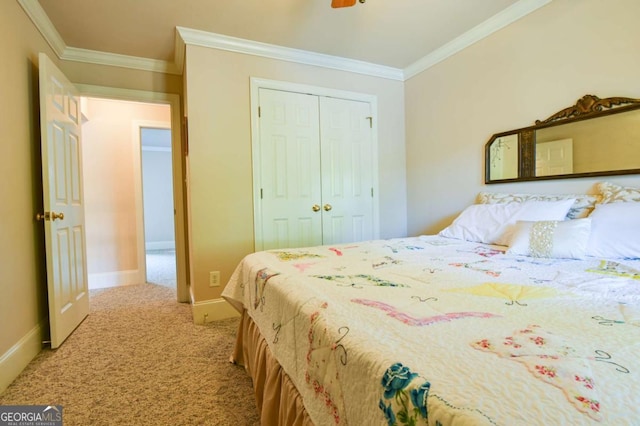 carpeted bedroom with crown molding, baseboards, a ceiling fan, and a closet