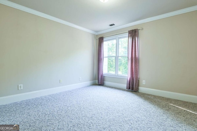 spare room with carpet floors, baseboards, ornamental molding, and visible vents