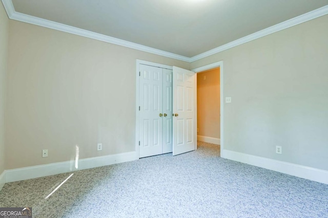 unfurnished bedroom with crown molding, baseboards, and carpet flooring