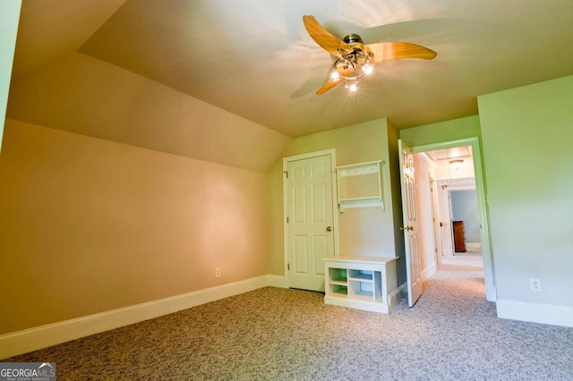 unfurnished bedroom featuring baseboards, carpet flooring, a ceiling fan, and vaulted ceiling