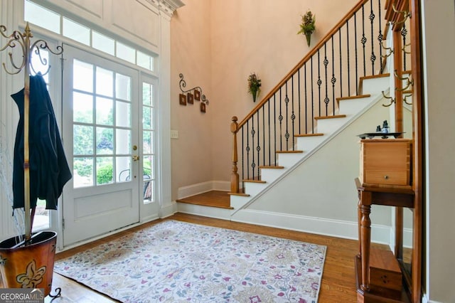 entryway with baseboards, stairs, and wood finished floors