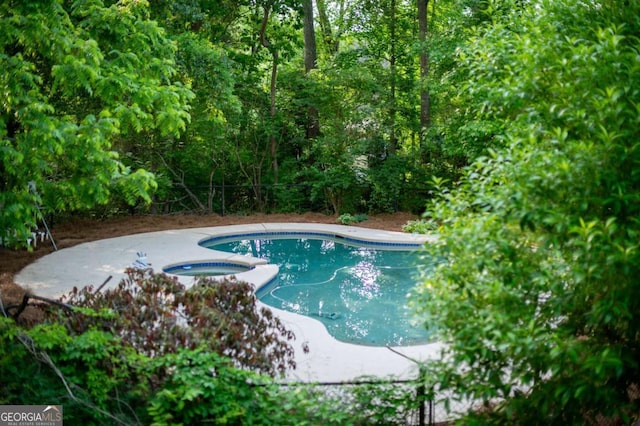 outdoor pool featuring an in ground hot tub
