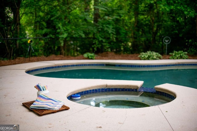 view of swimming pool with a pool with connected hot tub