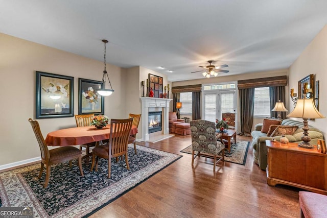 661 Village Field Ct NW, Suwanee, GA 30024 - dining space with a glass covered fireplace, baseboards, ceiling fan, and wood finished floors