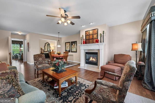 661 Village Field Ct NW, Suwanee, GA 30024 - living room with a premium fireplace, a ceiling fan, baseboards, and dark wood-style floors