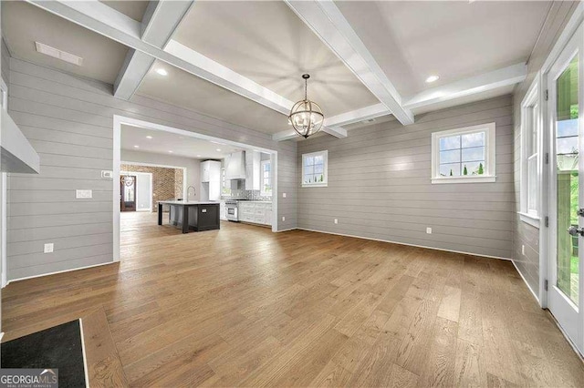 7235 Cordery Rd, Cumming, GA 30040 - unfurnished living room featuring light wood finished floors, wooden walls, and beamed ceiling