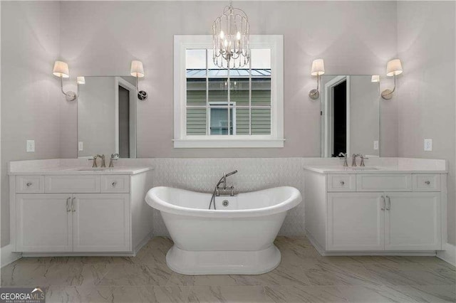 7235 Cordery Rd, Cumming, GA 30040 - full bathroom with a freestanding tub, two vanities, a wainscoted wall, marble finish floor, and an inviting chandelier
