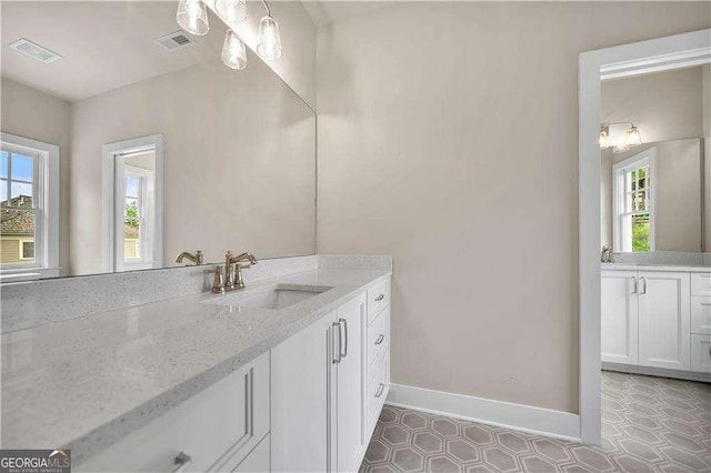 7235 Cordery Rd, Cumming, GA 30040 - bathroom with baseboards, visible vents, plenty of natural light, and vanity