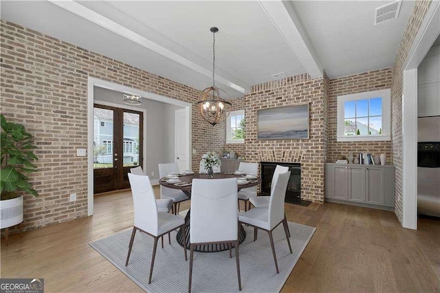 7235 Cordery Rd, Cumming, GA 30040 - dining area with a wealth of natural light, wood finished floors, brick wall, and beam ceiling