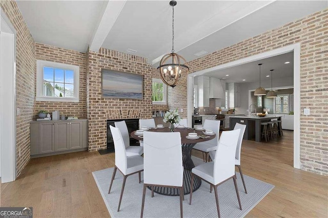 7235 Cordery Rd, Cumming, GA 30040 - dining room with light wood-style floors, a chandelier, brick wall, and beam ceiling