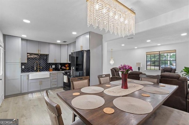 dining space featuring recessed lighting, an inviting chandelier, and light wood finished floors