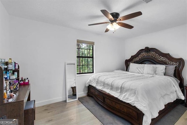 bedroom featuring baseboards, ceiling fan, and wood finished floors