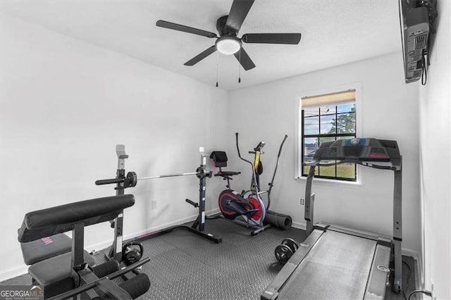workout room with baseboards and ceiling fan