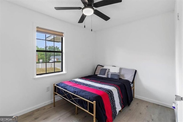 bedroom featuring baseboards, ceiling fan, and wood finished floors