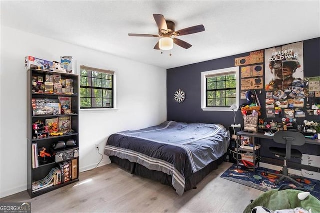 bedroom with baseboards, a ceiling fan, and wood finished floors