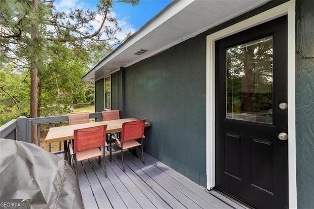 wooden deck featuring outdoor dining area