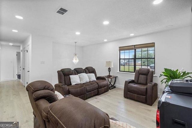 living room with baseboards, recessed lighting, light wood-style flooring, and visible vents