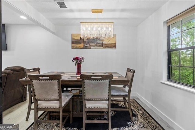 dining room with baseboards, visible vents, plenty of natural light, and an inviting chandelier