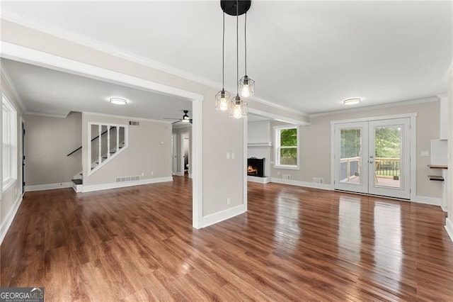 2979 Overwood Ln SW, Snellville, GA 30078 - unfurnished living room with ornamental molding, a lit fireplace, wood finished floors, stairs, and ceiling fan