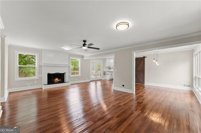 2979 Overwood Ln SW, Snellville, GA 30078 - unfurnished living room with a lit fireplace, ceiling fan, wood finished floors, and crown molding