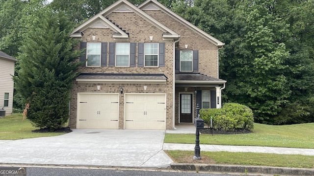 view of front facade with brick siding, a front lawn, an attached garage, and driveway