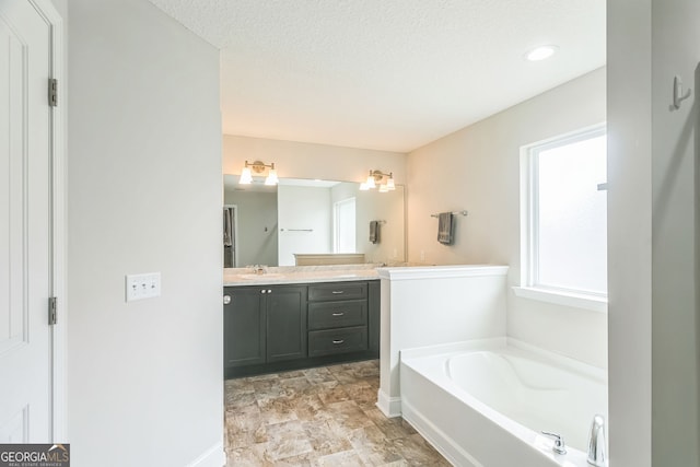 113 Hamlet Ct, Hinesville, GA 31313 - bathroom with vanity, baseboards, a textured ceiling, and a bath