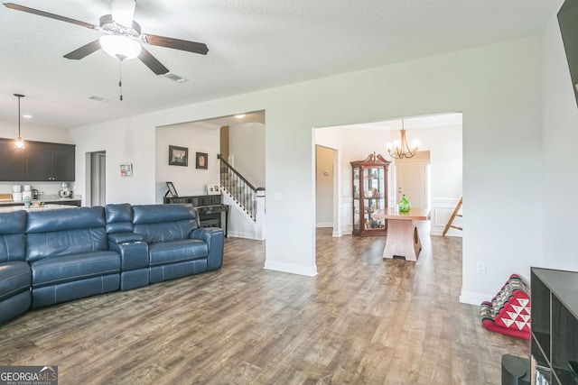 113 Hamlet Ct, Hinesville, GA 31313 - living room with visible vents, wood finished floors, stairway, and ceiling fan with notable chandelier