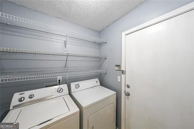 laundry room with laundry area, a textured ceiling, and washer and dryer