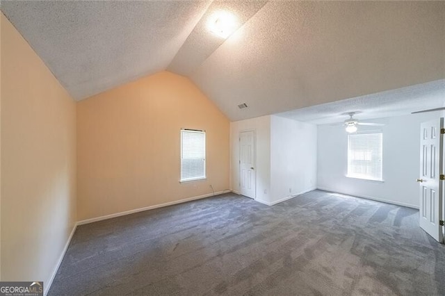 bonus room featuring a ceiling fan, a textured ceiling, vaulted ceiling, baseboards, and carpet