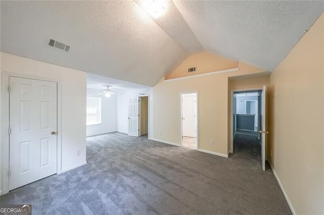 unfurnished living room featuring visible vents, carpet flooring, a textured ceiling, and vaulted ceiling