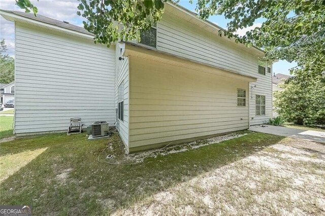 view of side of home with central AC unit