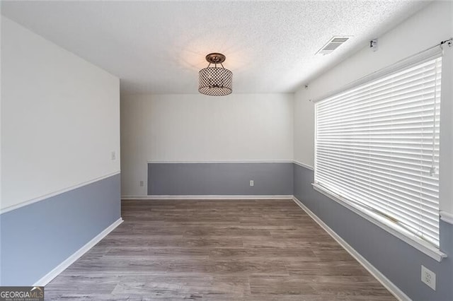 1528 Rogers Crossing Dr, Lithonia, GA 30058 - spare room featuring wood finished floors and a textured ceiling