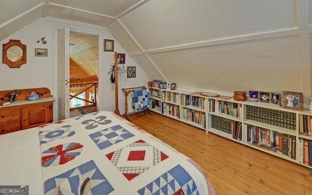 bedroom featuring wood finished floors and lofted ceiling