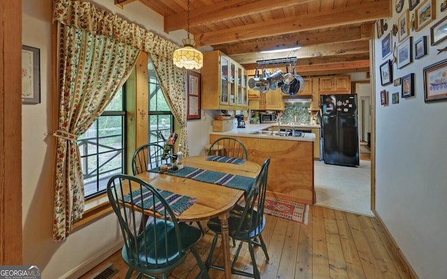 dining room featuring visible vents, wooden ceiling, baseboards, beamed ceiling, and light wood-style flooring