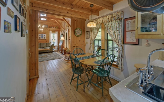 dining area with an inviting chandelier, wood ceiling, beam ceiling, and hardwood / wood-style floors