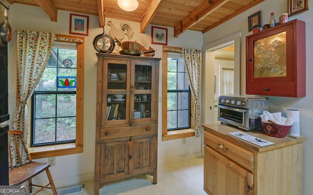 doorway with beamed ceiling, wooden ceiling, baseboards, and a toaster