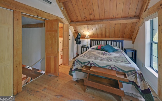 bedroom featuring lofted ceiling with beams, hardwood / wood-style flooring, and wooden ceiling