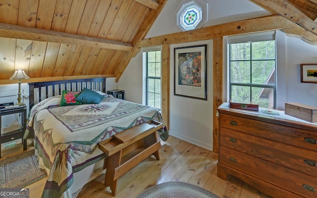 bedroom with baseboards, multiple windows, vaulted ceiling with beams, and light wood finished floors