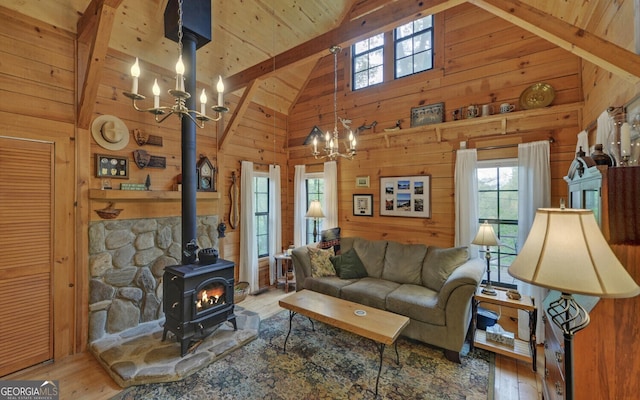 living room with high vaulted ceiling, plenty of natural light, hardwood / wood-style floors, and a notable chandelier