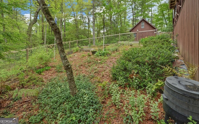 view of yard featuring an outdoor structure and fence