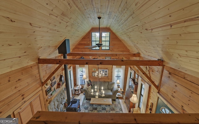 unfurnished living room featuring lofted ceiling and wooden walls