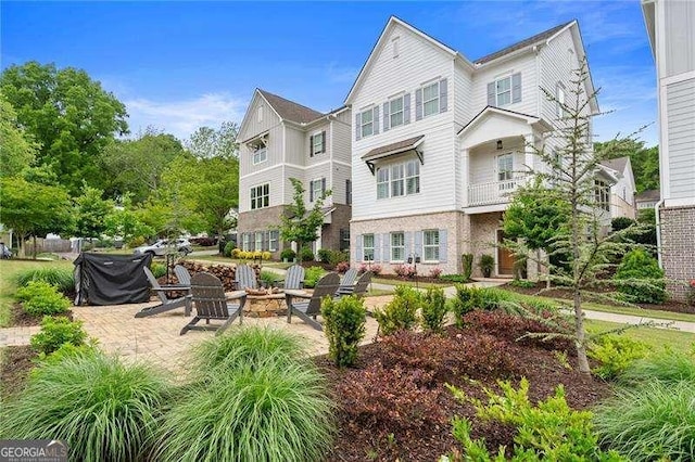 rear view of property featuring a patio and a fire pit