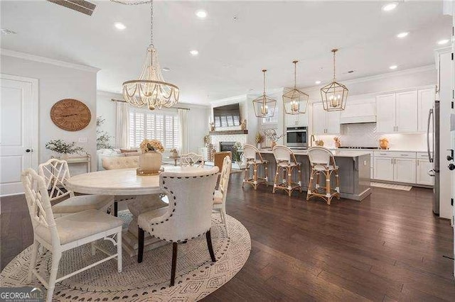 dining space with dark wood-style flooring, a notable chandelier, recessed lighting, visible vents, and ornamental molding